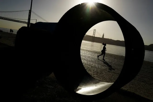 A woman runs near Tagus river in Lisbon, Portugal on November 9, 2023. (Photo by Pedro Nunes/Reuters)