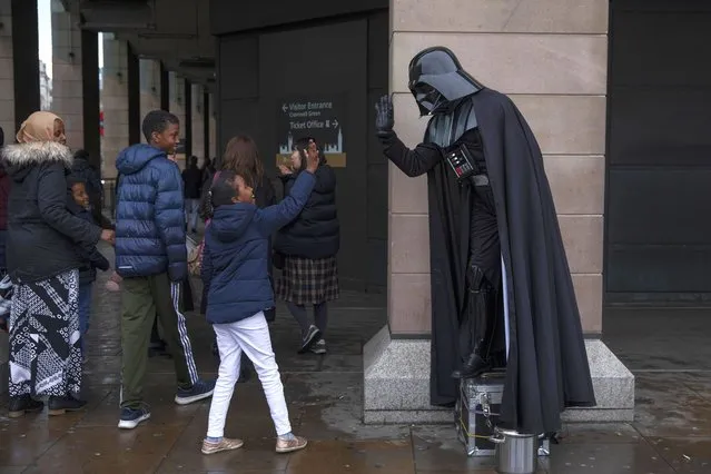 A young child gives a hi-five to a man dressed as the Star Wars character Darth Vader outside the Houses of Parliament on February 18, 2019 in London, England. Chuka Umunna MP along with Chris Leslie, Luciana Berger, Gavin Shuker, Angela Smith, Anne Coffey and Mike Gapes have announced they have resigned from the Labour Party today and will sit in the House of Commons as The Independent Group of Members of Parliament. (Photo by Dan Kitwood/Getty Images)