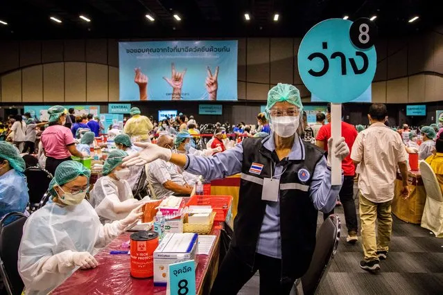 A volunteer nurse calls over the next patient to receive their Pfizer Vaccine at Central Westgate Mall on August 30, 2021 in Bangkok, Thailand. High risk Nonthaburi Province residents, who registered via the “Non Prom” app, received their first dose of the Pfizer-BioNTech COVID-19 Vaccine at Central Westgate Mall. Starting at 8am and concluding at 3pm, nurses and volunteers at Central Westgate provide mRNA vaccines to 9,000 Thai's. Those who qualified for the vaccine are over the age of 60, pregnant, or have pre-existing conditions. (Photo by Lauren DeCicca/Getty Images)