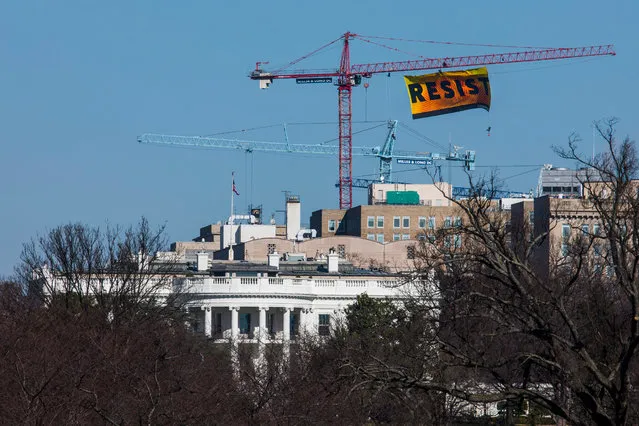 Seven Greenpeace activists unfurl a 70-foot by 35-foot banner reading the word “Resist” from a tower crane near the White House in Washington, DC, USA, 25 January 2017. The activists are calling for those who want to resist Trump's attacks on environmental, social, economic, and educational justice to contribute to a better America. (Photo by Jim Lo Scalzo/EPA)