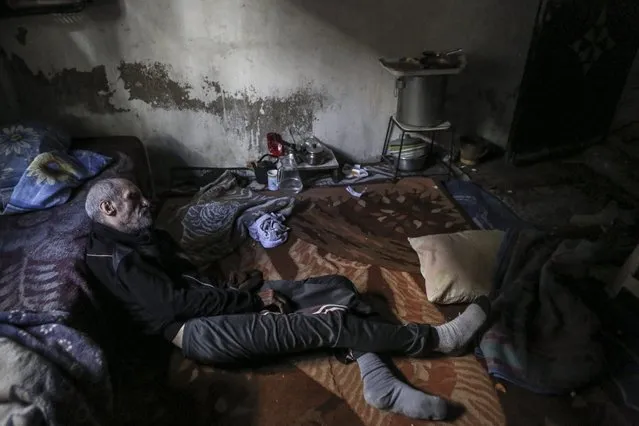 A photograph made available on 01 March 2016 shows Syrian elderly man, Abo Mustafa, living at his home, in the rebel-controlled neighborhood of Teshreen, Damascus, Syria, 29 February 2016. According to local sources, Abo Mostafa came from Edlib, in north of Syria. He suffered injuries two week ago after he fell on the ground and since then he was not able to walk. (Photo by Mohammed Badra/EPA)