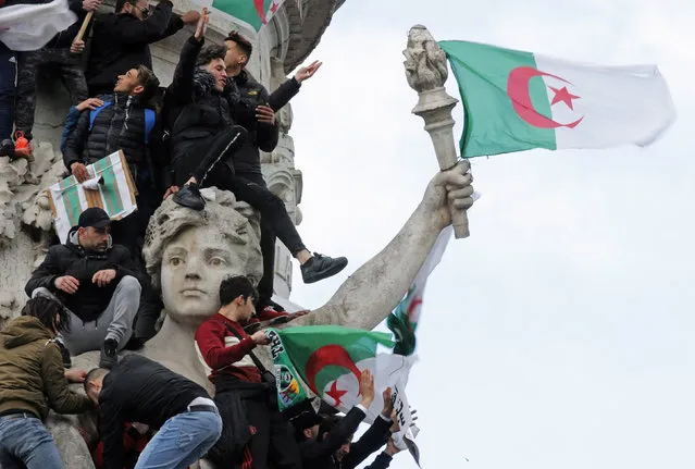Protestors hold Algerian flags as they attend a demonstration against President Abdelaziz Bouteflika on the Place de la Republique, in Paris, France, March 10, 2019. (Photo by Philippe Wojazer/Reuters)