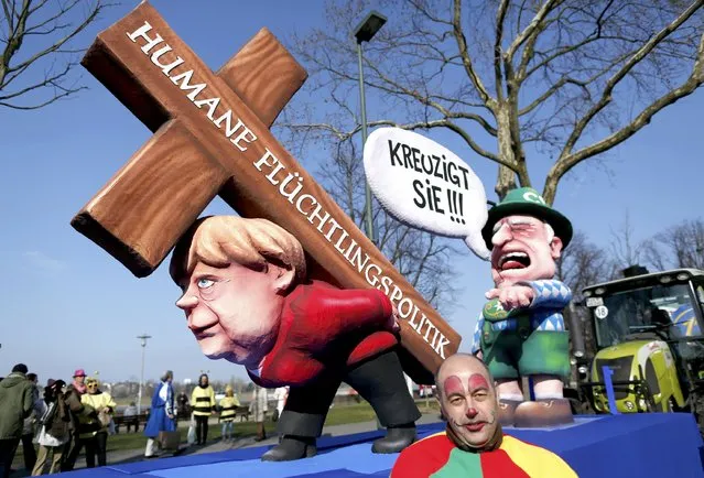 A carnival float with papier-mache caricatures mocking Bavarian Governor Horst Seehofer and German Chancellor Angela Merkel is displayed at a postponed “Rosenmontag” (Rose Monday) parade, at one location in Duesseldorf, Germany, March 13, 2016, after the original parade in February was cancelled due to severe weather. Words read “Crucify her' 'human politics for migrants”. (Photo by Ina Fassbender/Reuters)