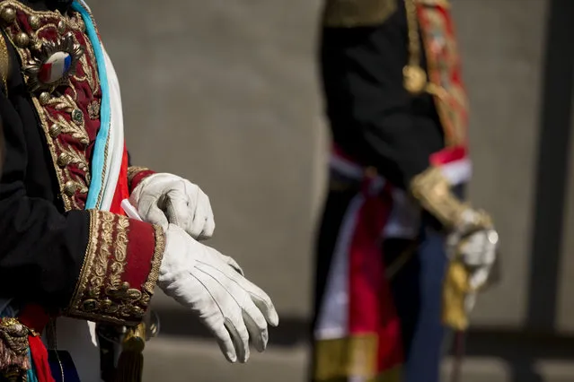 A Mexican man playing Napolean III adjusts his gloves during a parade before a reenactment of the battle of Puebla, between Zacapoaxtla Indians and the French army, during Cinco de Mayo celebrations in Mexico City, Tuesday, May 5, 2015. (Photo by Rebecca Blackwell/AP Photo)