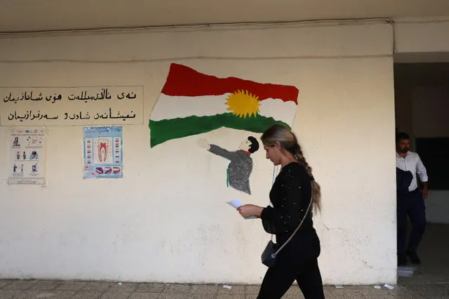 An Iraqi voter walks past a drawing of the Kurdistan region flag after casting ballot during a special voting day for the Iraqi legislative parliamentary election at a polling station in Erbil, the capital of the Kurdistan Region in Iraq, 08 October 2021. About 1,000,000 members of the Iraqi security and other forces in Iraq vote for the legislative election during a special voting day ahead of public's vote in the Iraqi legislative elections on 10 October 2021. (Photo by Gailan Haji/EPA/EFE)