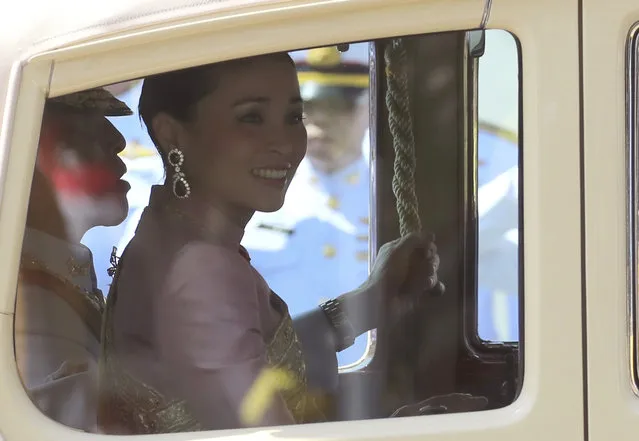Thailand's King Maha Vajiralongkorn, left, and Queen Suthida sit inside royal car drive pass people Saturday, May 4, 2019, in Bangkok, Thailand. Saturday began three days of elaborate centuries-old ceremonies for the formal coronation of Vajiralongkorn, who has been on the throne for more than two years following the death of his father, King Bhumibol Adulyadej, who died in October 2016 after seven decades on the throne. (Photo by Sakchai Lalit/AP Photo)