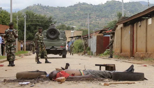 Soldiers stand near the body of a man who was burned alive by protesters in Burundi's capital Bujumbura, May 7, 2015. (Photo by Jean Pierre Aime Harerimana/Reuters)