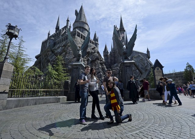 Guests pose before they enter Hogwarts School during a soft opening and media tour of “The Wizarding World of Harry Potter” theme park at the Universal Studios Hollywood in Los Angeles, California in this picture taken March 22, 2016. (Photo by Kevork Djansezian/Reuters)