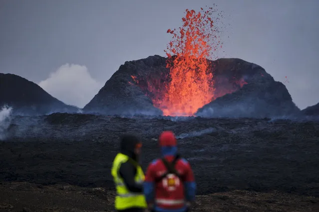 A view of flowing lava and billowing smoke from volcanic eruption between stora Skogfell and Hagafell in Reykjanes Peninsula of Iceland on March 21, 2024. A volcanic eruption commenced between Stora Skogfell and Hagafell, marking the seventh eruption since the onset of this period of volcanic activity on March 19th, 2021, in the region. Lava is currently flowing over a road. (Photo by Anton Brink/Anadolu via Getty Images)