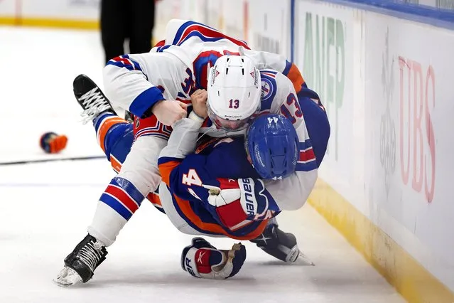 New York Rangers left wing Alexis Lafrenière (13) tackles New York Islanders center Jean-Gabriel Pageau (44) to the ice as they fight during the third period of an NHL hockey game, Wednesday, November 24, 2021, in Elmont, N.Y. The Rangers defeated the Islanders 4-1. (Photo by Rich Schultz/AP Photo)