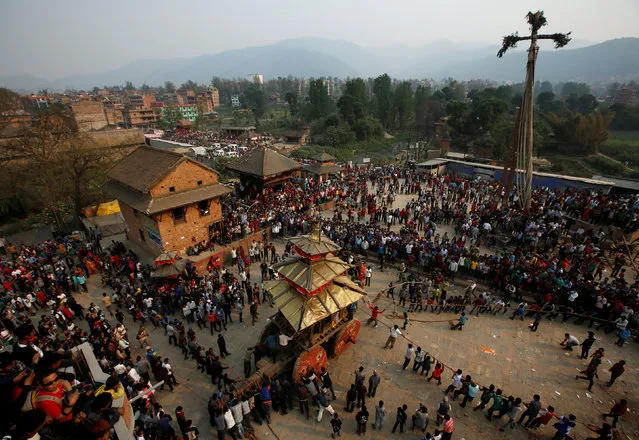The chariot of God Bhairab (C) is pulled near the “lingo”, a long wooden pole representing a phallus, before pulling it down during the Bisket festival at Bhaktapur, Nepal, April 13, 2016. (Photo by Navesh Chitrakar/Reuters)