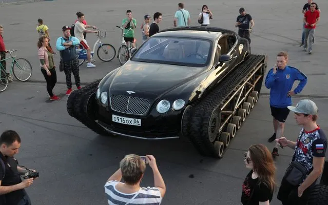 People gather around a caterpillar-tracked Bentley Continental GT, which was modified by Russian car engineering enthusiasts, during a demonstration in St. Petersburg, Russia on June 7, 2019. (Photo by Anton Vaganov/Reuters)