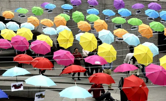 Visitors walk under the umbrellas symbolizing the earth's environment and peace along Cheonggye stream in Seoul, South Korea, Thursday, March 27, 2014. (Photo by Lee Jin-man/AP Photo)