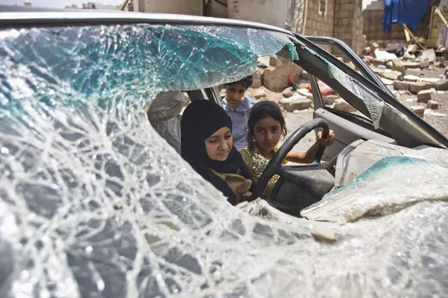 Yemeni girls play with a vehicle damaged by Saudi-led coalition airstrikes in Sanaa, Yemen, Monday, May 18, 2015. (Photo by Hani Mohammed/AP Photo)