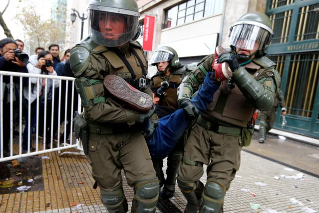 A student protester is detained outside the education ministry building during a rally to demand changes in the education system in Santiago, Chile April 28, 2016. (Photo by Ivan Alvarado/Reuters)