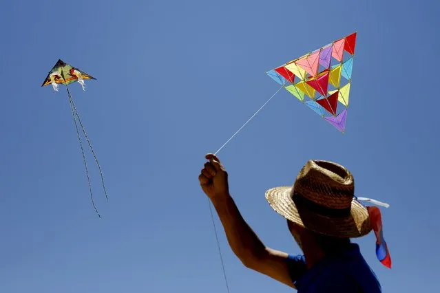A man flies a kite during the 13th International Kite Festival at the Moinhos beach in Alcochete near Lisbon, Portugal, June 28, 2015. (Photo by Hugo Correia/Reuters)