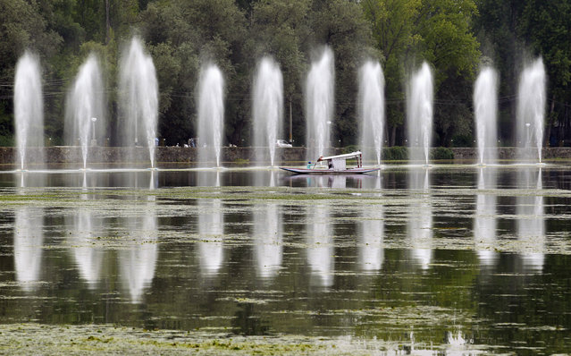 A Kashmiri man rows a boat past fountains in the polluted waters of Dal Lake, in Srinagar September 8, 2012. The lake has been polluted during decades of neglect and a separatist revolt. Dal Lake, the region's main tourist attraction which has drawn visitors from Mughal emperors to the Beatles star George Harrison, has shrunk from 25 sq km to 13 sq km since the 1980s, environmental campaigners say. (Photo by Fayaz Kabli/Reuters)