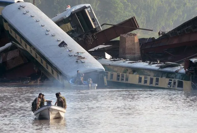 Pakistan army soldiers conduct a search operation after a train fell into a canal near Gujranwala, Pakistan, July 3, 2015. A train carrying hundreds of Pakistan military personnel and their families plunged into a canal on Thursday, killing 12 soldiers, when a bridge collapsed in what the army suspects was sabotage, officials said. (Photo by Reuters/Stringer)