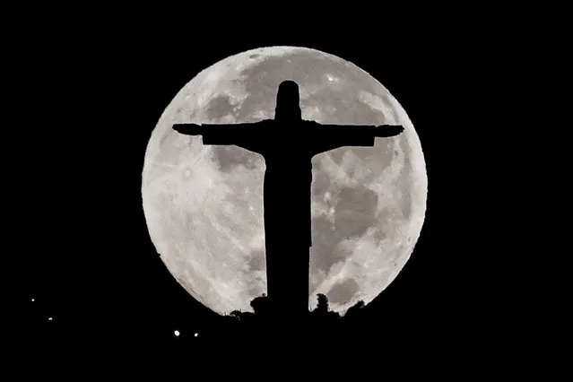 The Cristo Rey monument is silhouetted against the full moon in Cali, Colombia, early on June 17, 2019. (Photo by Luis Robayo/AFP Photo)
