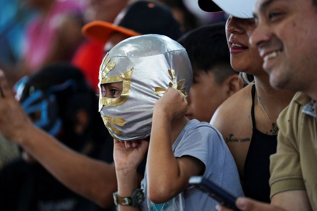 A boy wears a “Lucha Libre” mask as wrestlers engage in a “Lucha Libre” performance to raise awareness for climate change in the Iztapalapa neighborhood in Mexico City, Mexico, on June 8, 2024. (Photo by Toya Sarno Jordan/Reuters)