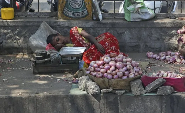 An Indian vendor selling onions on a sidewalk rests under the shade of a tree on a hot summer day in Hyderabad, India, Wednesday, April 20, 2016. Weeks of sweltering temperatures have caused more than 160 deaths in southern and eastern India, officials said Tuesday, warning that any relief from monsoon rains was still likely weeks away. Most of the heat-wave victims were laborers and farmers in the states of Telangana, Andhra Pradesh and Orissa, though temperatures elsewhere in India have also hit 45 degrees Celsius (113 Fahrenheit). (Photo by Mahesh Kumar A./AP Photo)