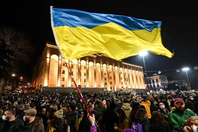 Demonstrators wave the Ukrainian flag during a rally in support of Ukraine in Tbilisi on March 1, 2022. (Photo by Vano Shlamov/AFP Photo)