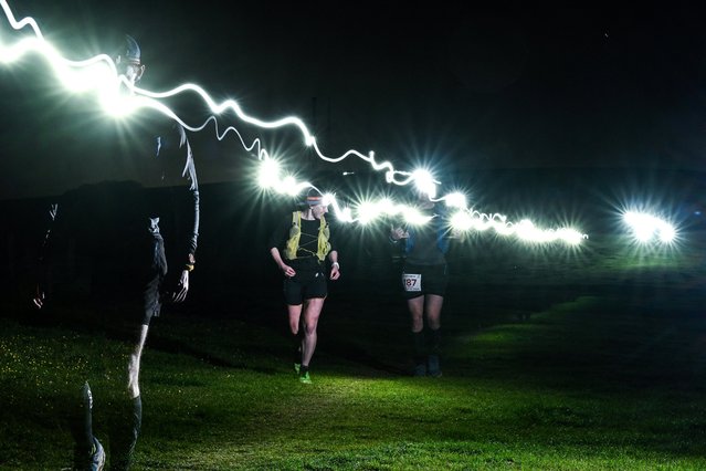 Runners use headtorches as they compete in Centurion South Downs Way 100 ultramarathon, at Firle Bostal near Lewes, south of London on June 9, 2024. The Centurion South Downs Way 100, is an ultramarathon, predominantly off road course, covering a distance of 100 miles (160,9 kilometres) and that takes the competitors along the South Downs Way from Winchester in Hampshire to Eastbourne in East Sussex. (Photo by Ben Stansall/AFP Photo)