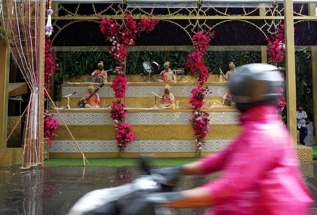 Folk musicians perform outside the home of Indian billionaire Mukesh Ambani on the day of the wedding of his son Anant Ambani in Mumbai, India, on July 12, 2024. (Photo by Hemanshi Kamani/Reuters)