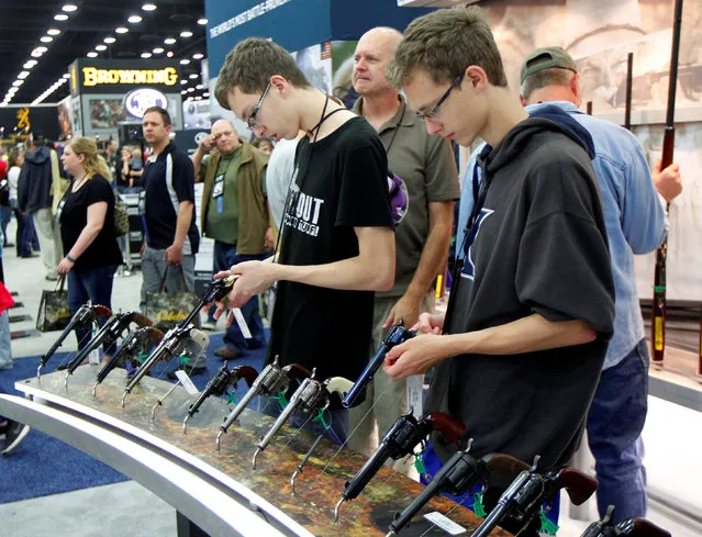 Gun enthusiasts look over Benelli USA guns at the National Rifle Association's annual meetings & exhibits show in Louisville, Kentucky, May 21, 2016. (Photo by John Sommers II/Reuters)