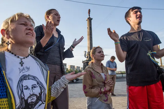 An interdenominational Christian group pray for Ukraine at the Kalmius embankmentt near Constitution square, May 23, 2014 in Donetsk. The group is on the 77th day of prayer for Ukraine and have been attacked and intimidated frequently. Ukrainian security forces have been tightening the ring around Donetsk, and the number of clashes has increased in recent days. (Photo by Evelyn Hockstein/The Washington Post)