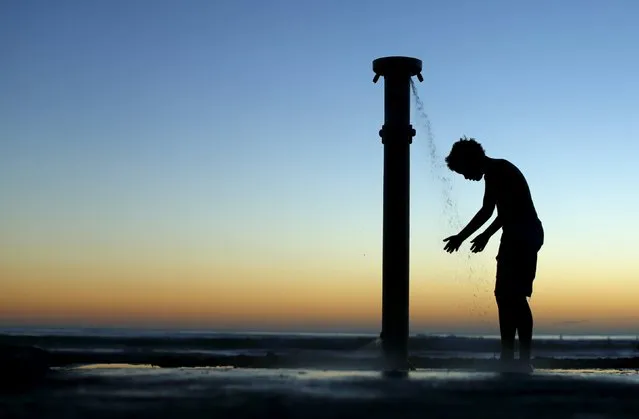 A boy showers off after sunset at the beach in Cardiff-by-the-Sea, California in this March 10, 2014 file photo. (Photo by Mike Blake/Reuters)