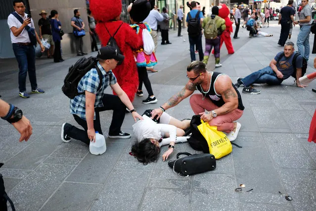People attend injured pedestrians a moment after a car plunged into them in Times Square in New York on May 18, 2017. (Photo by Jewel Samad/AFP Photo)