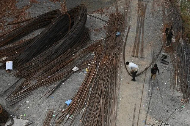 Migrant labourers work at a building construction site in Srinagar on November 1, 2019. (Photo by Tauseef Mustafa/AFP Photo)