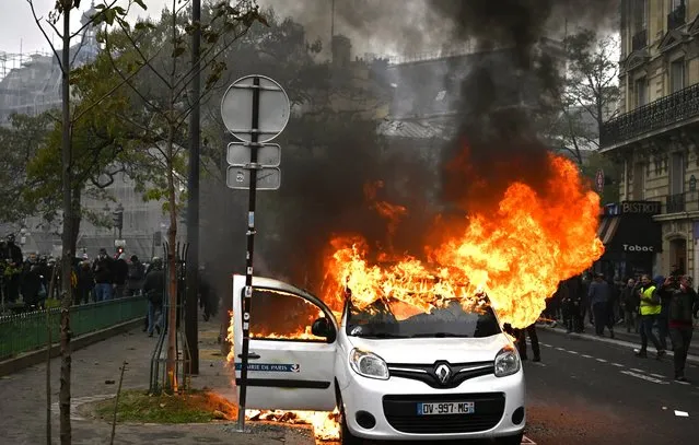 A burning vehicle is seen during “Gilets Jaunes” (Yellow Vests) protests on Place d'Italie to mark the first anniversary of the movement, in Paris, France on November 16, 2109. (Photo by Mustafa Yalcin/Anadolu Agency via Getty Images)