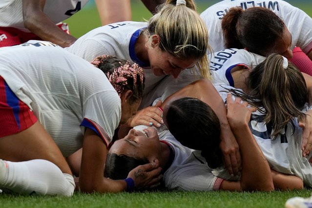 US soccer player Sophia Smith is mobbed by teammates after scoring an extra-time goal against Germany on Tuesday, August 6, 2024. The Americans won 1-0 to advance to the gold-medal match. (Photo by Silvia Izquierdo/AP Photo)