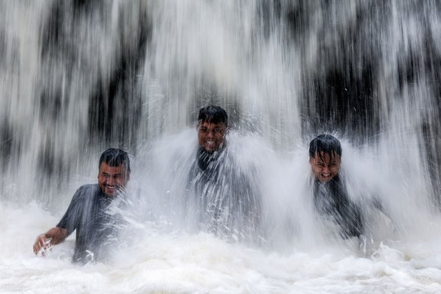 A slow shutter speed picture effect shows visitors react as they swim under a waterfall during a hot day in Hulu Selangor, outside Kuala Lumpur, Malaysia, 30 April 2024. The Malaysian Meteorological Department (MetMalaysia) issues a Level 1 hot weather alert for 18 areas on 30 April. (Photo by Fazry Ismail/EPA/EFE)