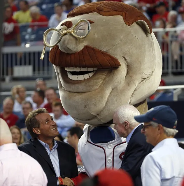 Sen. Jeff Flake, R-Ariz., left, and Sen. John McCain, R-Ariz., second from right, stand with “Racing President” mascot Teddy Roosevelt during a baseball game between the Washington Nationals and the Arizona Diamondbacks at Nationals Park, Tuesday, Aug. 4, 2015, in Washington. (Photo by Alex Brandon/AP Photo)