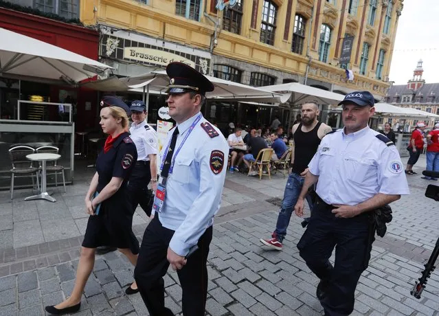 Russian police officers walk through a square in downtown Lille, Wednesday, June 15, 2016 after being called into to bolster security ahead of the Euro 2016 Group B soccer match between Russia and Slovakia at the Pierre Mauroy stadium in Villeneuve d'Ascq, near Lille. UEFA gave Russia a suspended disqualification from the tournament after violence at their previous match against England in Marseille. (Photo by Darko Bandic/AP Photo)