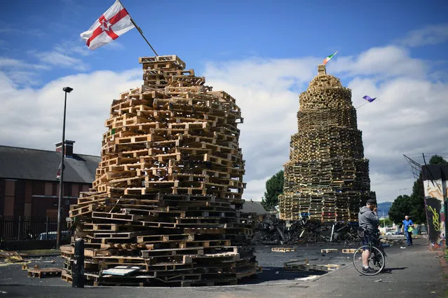 Loyalists finish a bonfire in East Belfast in preparation for the 11th night celebrations on July 11, 2017 in Belfast, Northern Ireland. Tradition holds that the bonfires commemorate the lighting of fires on the hills to help Williamite ships navigate through Belfast Lough at night when Protestant King William III and his forces landed at Carrickfergus to fight the Catholic Jacobites, supporters of the exiled Catholic King James II. The bonfires also mark the beginning of the annual 12th of July Orange parades. (Photo by Jeff J. Mitchell/Getty Images)