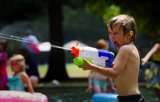 Five-year-old Cian Fitzgerald of West Seattle is full of enthusiasm as he shoots water out of his squirt gun at the Lincoln Park wading pool Tuesday, July 7, 2015. (Photo by Ellen M. Banner/The Seattle Times)