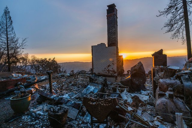 The sun sets over the remains of a house that was destroyed in the Park Fire near Forest Ranch, Calif., Saturday, July 27, 2024. (Photo by Nic Coury/AP Photo)