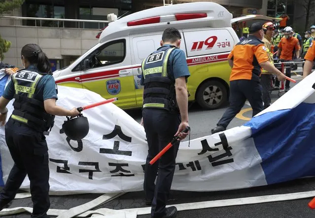South Korean police officers and firefighters check around the scene of a fire in Daegu, South Korea, Thursday, June 9, 2022. Multiple people were killed and dozens of others were injured Thursday in the fire that spread through the office building in South Korea's Daegu city, local fire and police officials said. (Photo by Park Se-jin/Yonhap via AP Photo)
