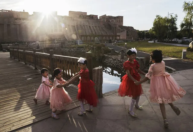 Ethnic Uyghur girls dance on the holiday of Eid Al Fitr on June 26, 2017 in the old town of Kashgar, in the far western Xinjiang province, China. (Photo by Kevin Frayer/Getty Images)