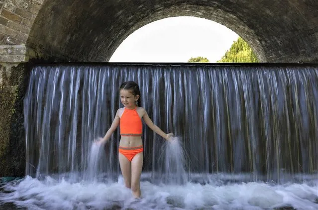 Luxey, 7, plays in the waterfall under Five Arches Bridge on June 15, 2022 in London, England. Hot air originating in North Africa and travelling up through Spain brings temperatures of up to 32c to the UK in the coming days. (Photo by Dan Kitwood/Getty Images)