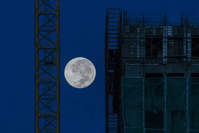 The moon is seen near a construction site in Kuala Lumpur on December 13, 2019. (Photo by Mohd Rasfan/AFP Photo)