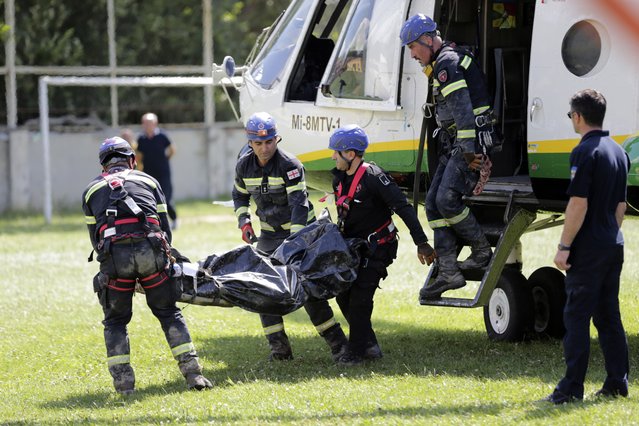 Rescue workers carry the body of a victim of landslide near Shovia, bout 140 kilometers (85 miles) northwest of the capital Tbilisi, Georgia, Friday, August 4, 2023. At least seven people were killed and more than 30 are missing after a landslide hit a resort area in the mountains of the country of Georgia, officials and news reports said Friday. (Photo by Zurab Tsertsvadze/AP Photo)