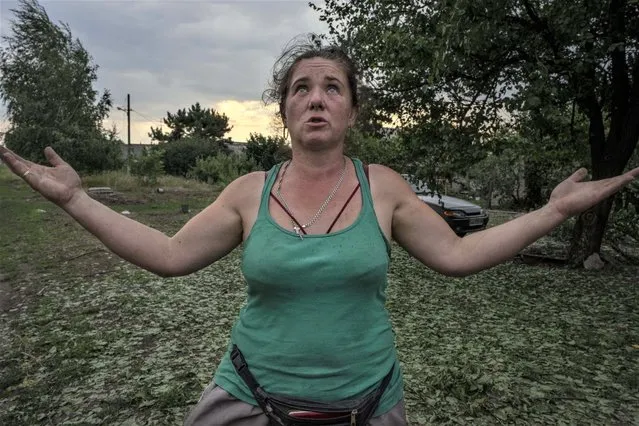 Tetiana Pashko, a 43-year-old resident, speaks in front of her damaged home, in the aftermath of a rocket attack on the outskirts of Pokrovsk, eastern Ukraine, Saturday, July 16, 2022. (Photo by Nariman El-Mofty/AP Photo)