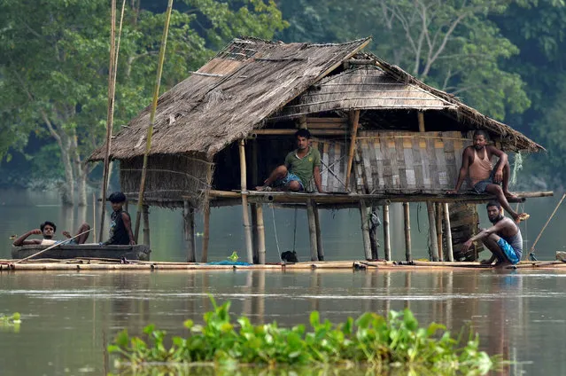 Villagers take shelter at a partially submerged house following floods at Baghmari village in Nagaon district, Assam, August 15, 2017. (Photo by Anuwar Hazarika/Reuters)