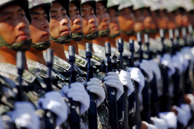 Soldiers of China's People's Liberation Army march with their weapons during a training session for a military parade to mark the 70th anniversary of the end of World War Two, at a military base in Beijing, China, August 22, 2015. (Photo by Damir Sagolj/Reuters)