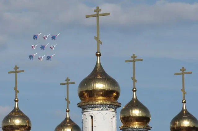 MiG-29 jet fighters of the Strizhi (Swifts) and Sukhoi Su-27 jet fighters of the Russkiye Vityazi (Russian Knights) aerobatic teams perform near an Orthodox church during a demonstration flight at the MAKS International Aviation and Space Salon in Zhukovsky outside Moscow, Russia in this August 28, 2013 file photo. The MAKS International Aviation and Space Salon 2015 is expected to open in Russia this week. (Photo by Tatyana Makeyeva/Reuters)